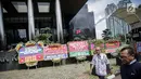 Warga melintas dekat karangan bunga berisi dukungan pada KPK di halaman Gedung KPK, Jakarta, Senin (20/11). Karangan bunga tersebut sebagai bentuk dukungan masyarakat kepada KPK terhadap pemberantasan kasus korupsi e-KTP. (Liputan6.com/Faizal Fanani)