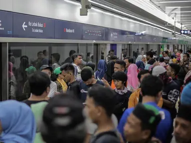 Warga mengantre menunggu kereta MRT di pintu masuk Stasiun MRT Bundaran HI, Jakarta, Minggu (24/3). Moda Raya Terpadu (MRT) Jakarta Fase 1 dengan rute Bundaran HI - Lebak Bulus resmi beroperasi. (Liputan6.com/Faizal Fanani)