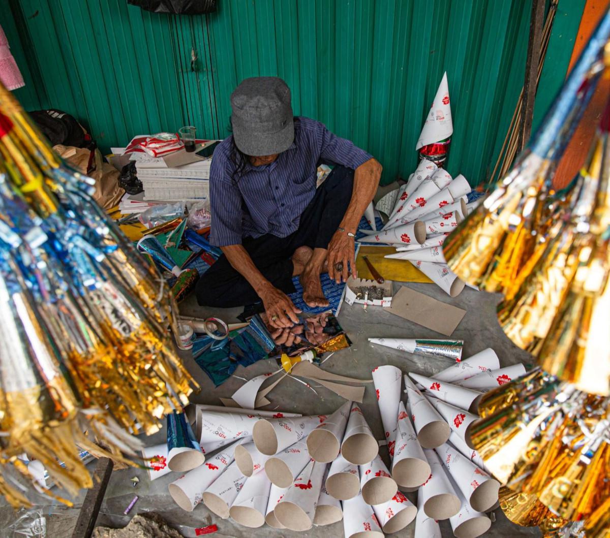 Para pembuat terompet dan aksesoris menyambut perayaan Tahun Baru  2024 mulai menjamur di kawasan Glodok, Jakarta, Selasa (26/12/2023).