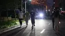 Warga berjalan di dalam komunitas perumahan di Shanghai (11/4/2022). Banyak penduduk di kota berpenduduk 26 juta itu telah dikurung di rumah hingga tiga minggu karena China mempertahankan strategi "nol-COVID" dalam menangani wabah dengan isolasi ketat dan pengujian massal. (AP Photo)