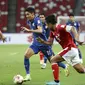 Gelandang Thailand, Bordin Phala (tengah) mengontrol bola melewati bek Timnas Indonesia Fachruddin Aryanto dalam pertandingan Babak Final Leg 1 Piala AFF 2020 di National Stadium, Singapura, Rabu (29/12/2021). Laga antara Indonesia vs Thailand berakhir dengan skor 0-4 (AP Photo/Suhaimi Abdullah)