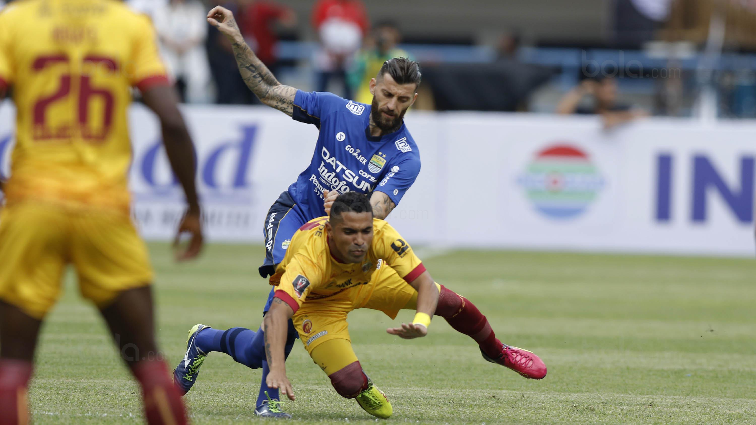 Striker Sriwijaya FC, Alberto Goncalves, dijatuhkan bek Persib Bandung, Bojan Malisic, pada laga Grup A Piala Presiden di Stadion GBLA, Bandung, Selasa (16/1/2018). Persib menang 1-0 atas Sriwijaya FC. (Bola.com/M Iqbal Ichsan)