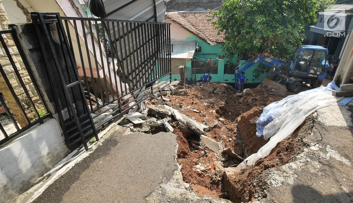 Petugas dibantu alat berat membersihkan puing longsoran di Perumahan Pesona Kalisari, Pasar Rebo, Jakarta, Selasa (27/11). Para petugas terdiri dari Dinas Tata Air, Dinas Bina Marga, Tagana, unsur Kelurahan Kalisari dan PPSU (Liputan6.com/Herman Zakharia)