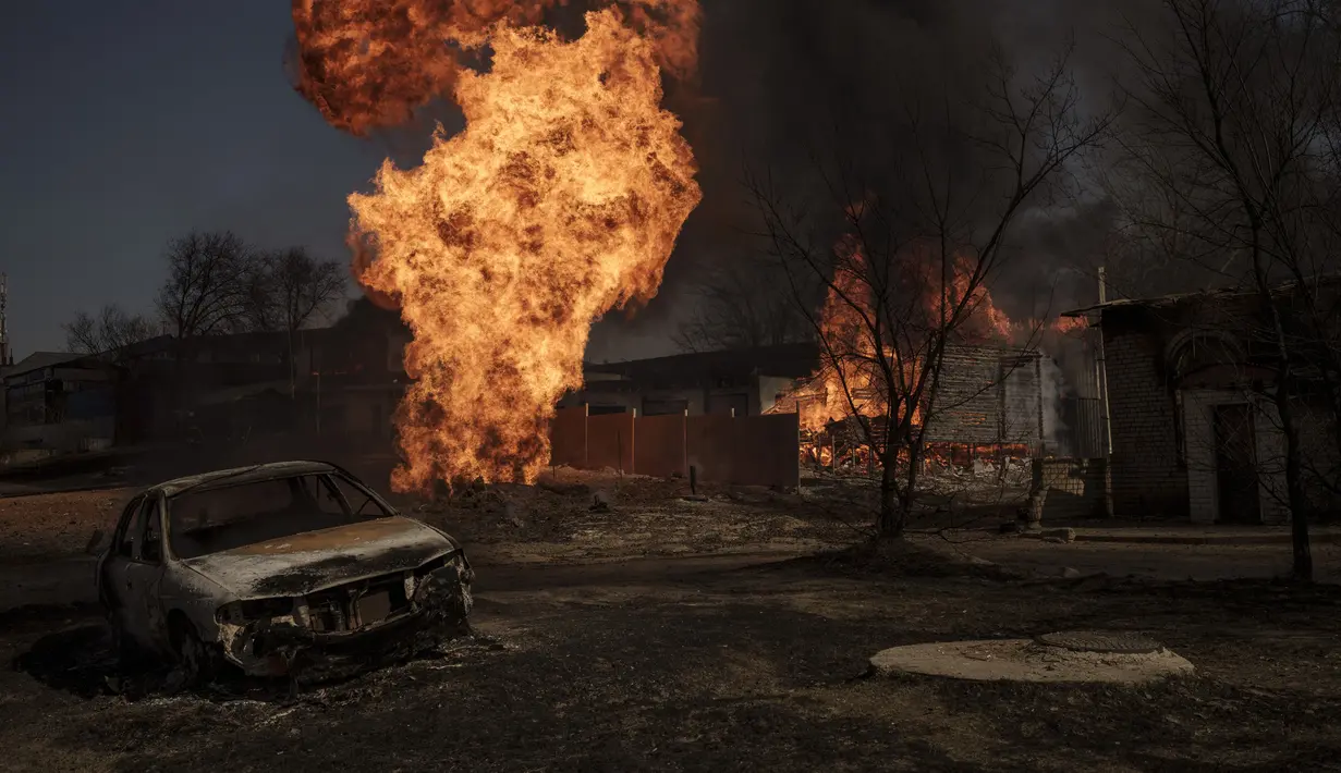 Kobaran api dan asap mengepul menyusul serangan Rusia di Kharkiv, Ukraina, 25 Maret 2022. (AP Photo/Felipe Dana)