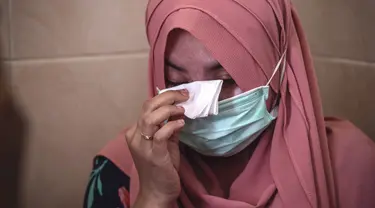 Berda Asmara menghapus air mata saat berbicara tentang suaminya Serda Mes Guntur Ari Prasetyo di rumah mereka di Surabaya, Jumat (23/4/2021). Serda Mes Guntur Ari Prasetya merupakan juru diesel di kapal selam KRI Nanggala-402 yang hilang kontak. (Juni Kriswanto/AFP)
