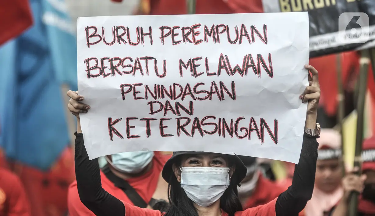 Massa buruh perempuan membentangkan poster tuntutan saat turut dalam aksi menolak UU Cipta Kerja di kawasan Patung Kuda, Jakarta, Selasa (10/11/2020). (merdeka.com/Iqbal S. Nugroho)