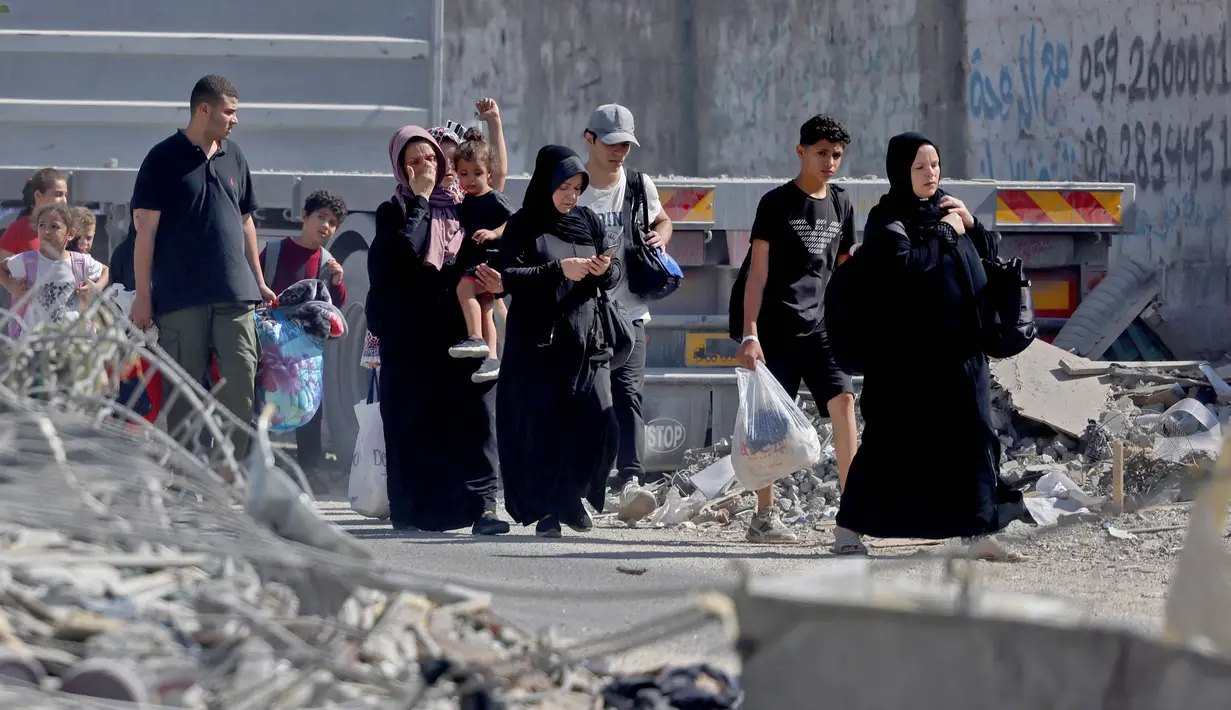 Warga Palestina dengan barang-barang mereka mengungsi ke daerah yang lebih aman di kota Gaza setelah serangan udara Israel, pada 13 Oktober 2023. (MOHAMMED ABED/AFP)