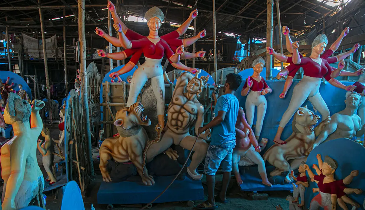 Seniman membuat patung Dewi Durga jelang Festival Durga Puja di Gauhati, India, Jumat (16/10/2020). Para pejabat kesehatan memperingatkan tentang potensi penyebaran COVID-19 selama musim festival keagamaan dengan pertemuan besar di kuil dan distrik perbelanjaan. (AP Photo/Anupam Nath)