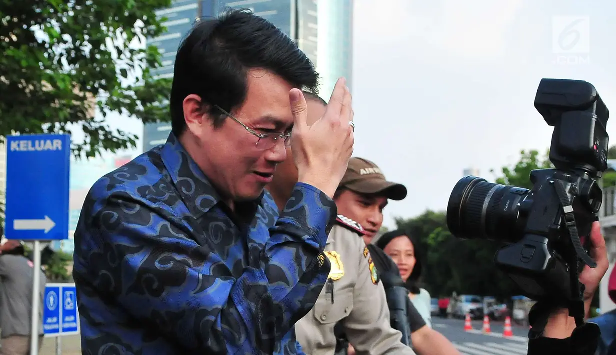 Dedi Prijono menutupi wajahnya saat dimintai keterangan awak media usai menjalani pemeriksaan di gedung KPK, Jakarta (1/8). Untuk kepentingan penyidikan, Dedi dicegah untuk berpergian ke luar negeri selama 6 bulan kedepan. (LIputan6.com/Helmi Afandi)