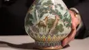 Sebuah vas China antik yang diyakini berasal dari masa Dinasti Qing pada abad ke-18 diperlihatkan di rumah lelang Sotheby, Paris, Selasa (22/5). Vas tersebut lama tersimpan di dalam sebuah kotak sepatu milik satu keluarga di Perancis. (AFP/Thomas SAMSON)