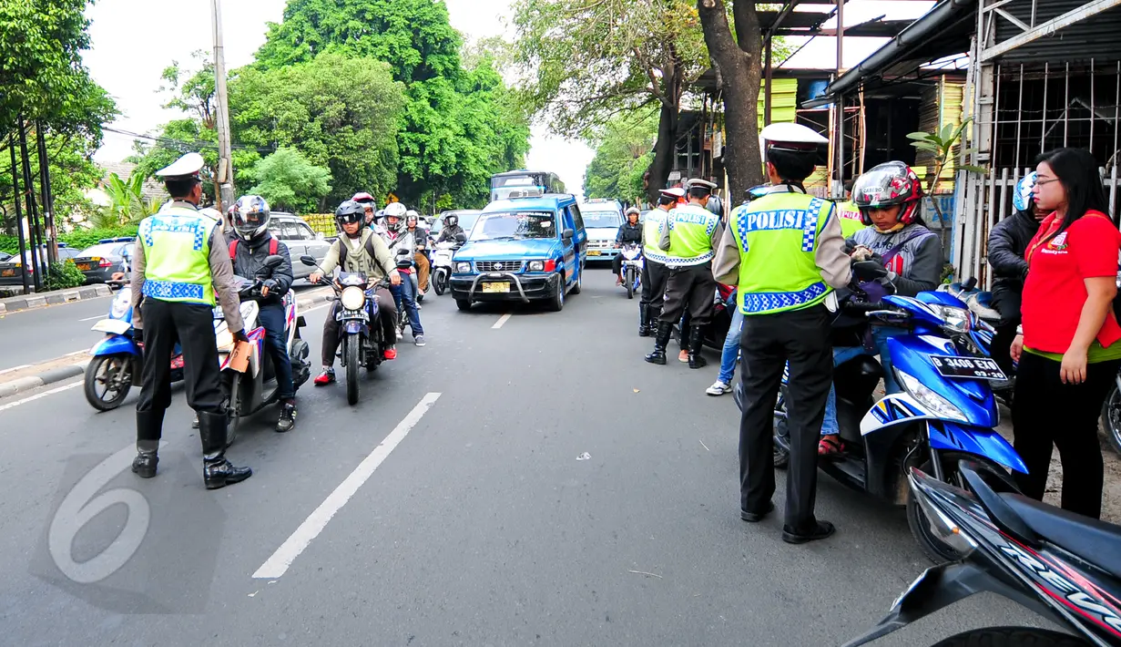 Polantas memberhentikan sejumlah kendaraan ketika Operasi Patuh Jaya di sepanjang Jalan Raya Bogor, Jakarta, Selasa(2/6/2015). Operasi tersebut untuk meningkatkan ketertiban berlalu lintas, yang dilaksanakan pada 29 Mei-9 Juni. (Liputan6.com/Yoppy Renato)