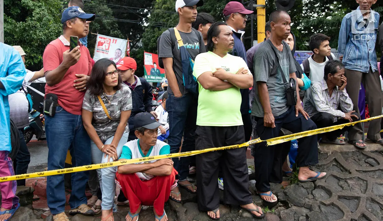 Warga melihat proses evakuasi KRL yang anjlok di kawasan Kebon Pedes, Bogor, Jawa Barat, Minggu (10/3). Penanganan KRL anjlok dilakukan dengan menggunakan crane yang didatangkan dari Bandung. (Liputan6.com/Immanuel Antonius)