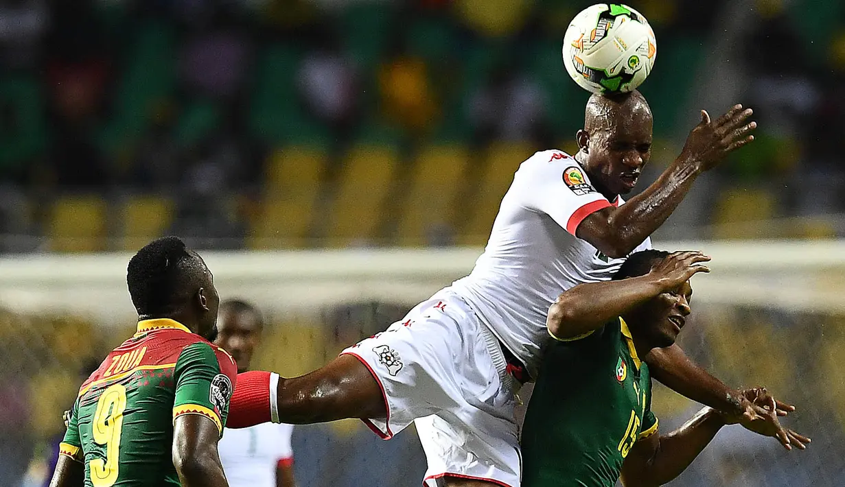 Gelandang Burkina Faso, Charles Kabore, duel udara dengan gelandang Kamerun, Sebastien Siani. Penguasaan bola kedua negara berjalan imbang, namun Kamerun lebih sering melakukan tembakan ke arah gawang. (AFP/Gabriel Bouys)