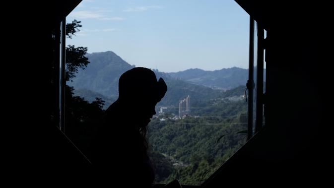 Turis saat mengunjungi Kuil Tao di gua Gunung Yinhe di distrik Xindian, Kota Taipei Baru, Taiwan (29/12/2019). Libur Natal dan Tahun Baru, bagi sebagian warga Taiwan memanfaatkan waktunya untuk berkunjung ke Kuil Tao untuk berwisata maupun memanjatkan doa. (AFP Photo/Sam Yeh)