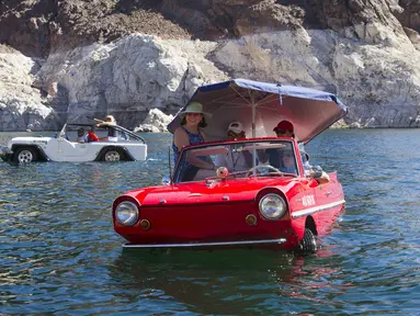 Mobil amfibi Panther WaterCar (kiri), yang dikemudikan Bob Davis dan Amphicar 1963, dikemudikan Rob Vondracek saat festival Las Vegas Amphicar Swim di Danau Mead, Nevada, Jumat (9/10). (REUTERS/Steve Marcus)