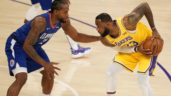Pemain Lakers LeBron James berduel dengan bintang Clippers Kawhi Leonard di laga pembuka NBA 2020-2021 (AP)