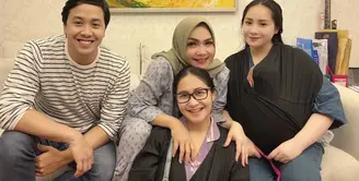 Di sini, Rieta Amilia terlihat berkumpul bersama ketiga anaknya, termasuk Nagita Slavina. Ia mengenakan dress gamis bermotif mini flower bernuansa abu-abu muda. Ia padukan dengan jilbab segiempat polos berwarna hijau. Foto: Instagram.