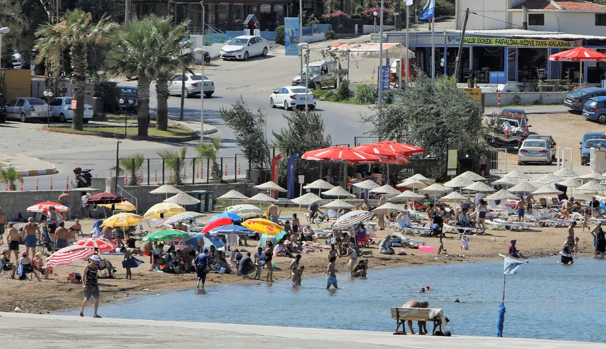 Warga berlibur di sebuah pantai di Distrik Ayvalik, Provinsi Balikesir, Turki, 4 Agustus 2020. Ramainya kunjungan warga Turki ke pantai-pantai selama liburan empat hari Idul Adha pekan lalu memicu kekhawatiran merebaknya kembali pandemi COVID-19 di negara itu. (Xinhua/Osman Orsal)