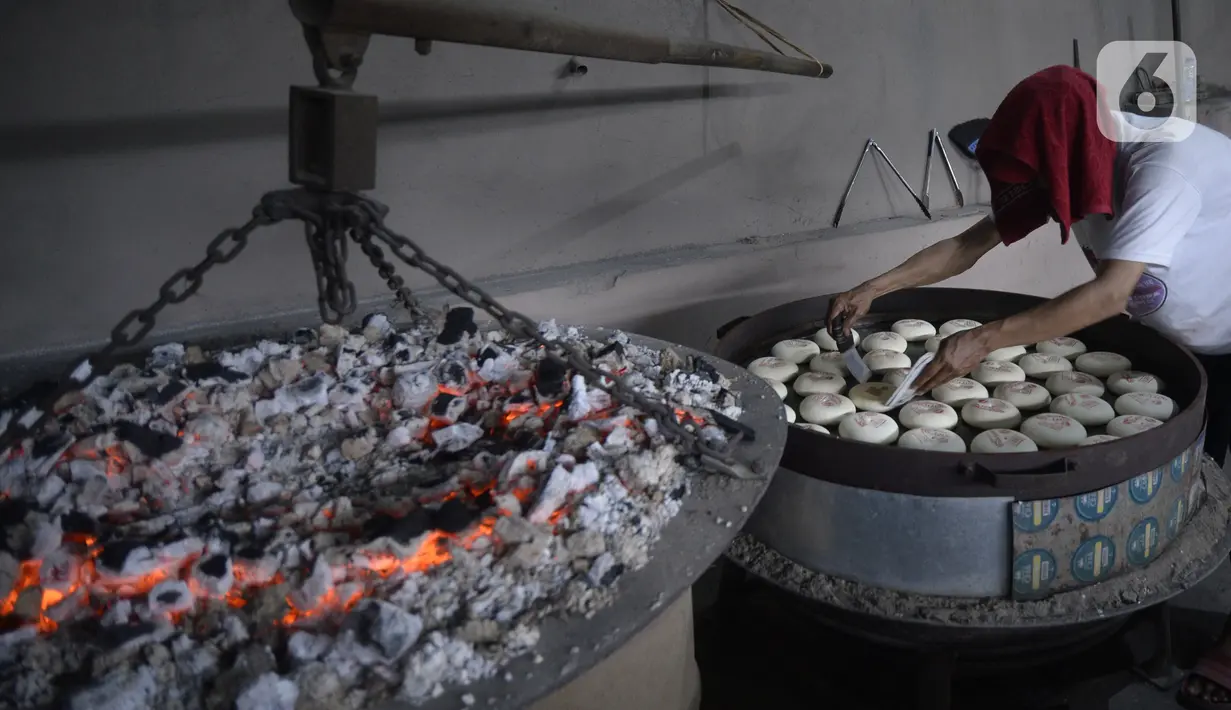 Pekerja menyelesaikan pembuatan kue bulan di Industri Rumahan Kue Bulan Putri Lauw, Pondok Sentul, Ciater, Tangerang Selatan, Selasa (10/11/2020). Pada masa pandemi sekarang, produksi kue tradisional khas Tionghoa tersebut menurun sesuai pesanan pembeli. (merdeka.com/Dwi Narwoko)
