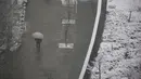 Seseorang berjalan di atas salju di Tokyo, Kamis (6/1/2022). Hujan salju lebat mendesak orang untuk bersiap menghadapi kemungkinan gangguan lalu lintas dan jalan yang tertutup es. (AP Photo/Koji Sasahara)