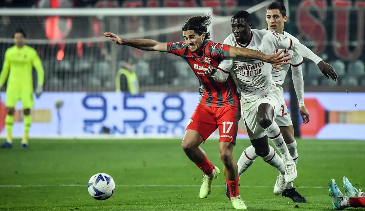 Pemain Cremonese Leonardo Sernicola (tengah) berebut bola dengan pemain AC Milan Fode Ballo-Toure (kanan) pada pertandingan sepak bola Serie A Liga Italia di Stadion Giovanni-Zini, Cremona, Italia, 8 November 2022. Pertandingan berakhir imbang 0-0. (Filippo MONTEFORTE/AFP)