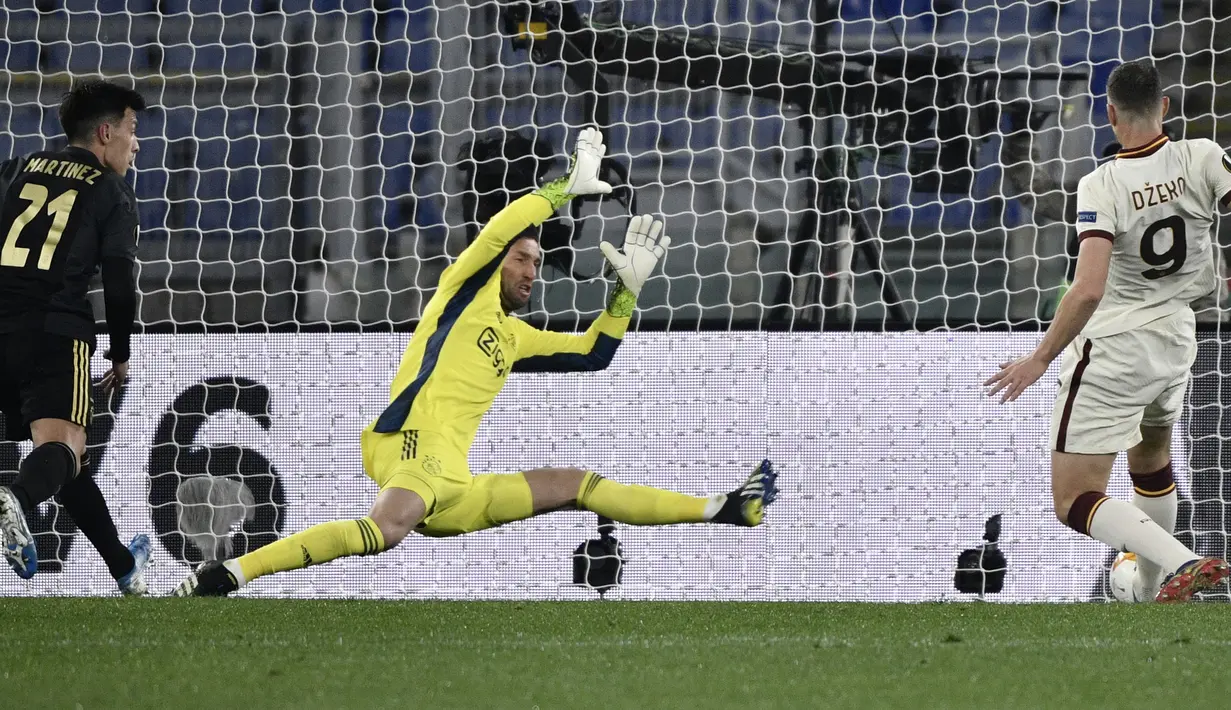Striker AS Roma, Edin Dzeko (kanan) mencetak gol penyeimbang 1-1 ke gawang Ajax Amsterdam yang dikawal kiper Maarten Stekelenburg dalam laga leg kedua perempatfinal Liga Europa 2020/2021 di Olimpico Stadium, Roma, Kamis (15/4/2021). AS Roma bermain imabng 1-1 dengan Ajax. (AFP/Filippo Monteforte)
