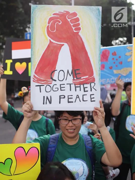 Warga menunjukkan poster saat melakukan kampanye tentang perdamaian dunia saat car free day di kawasan Bunderan HI, Jakarta, Minggu (27/5). Kampanye tersebut juga bertujuan untuk mencegah perpecahan. (Liputan6.com/Faizal Fanani)