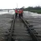 Petugas Daops 3 Cirebon tengah memeriksa kerusakan akibat banjir yang merendam jalur kereta api di perlintasan Brebes Jawa Tengah. (Istimewa / Panji Prayitno)