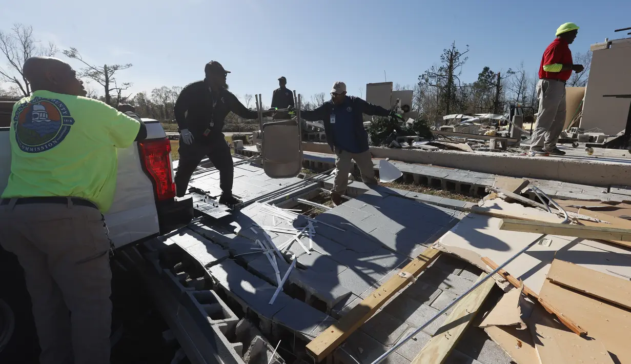 Para pekerja memindahkan kursi dari Pusat Komunitas Flatwood setelah badai tornado menghancurkan fasilitas tersebut dan menyebabkan beberapa orang tewas di Flatwood, Alabama (30/11/2022). (AP Photo/Butch Dill)