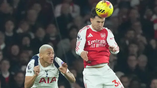 Martin Zubimendi dari Arsenal menyundul bola di depan pemain Tottenham, Richarlison