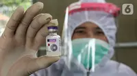 Bidan lengkap dengan baju Alat Pelindung Diri (APD) menunjukan vaksin DPT untuk anak di Posko Imunisasi, Kelurahan Bakti Jaya, Tangerang Selatan, Senin (11/5/2020). Pelayanan imunisasi tetap berjalan sesuai jadwal meski pandemi Covid-19. (Liputan6.com/Fery Pradolo)