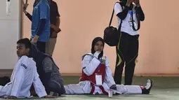 Peserta perempuan melakukan pemanasan sebelum bertanding pada Kejuaraan Terbuka Taekwondo di Banda Aceh (17/7/2019). Kejuaraan Taekwondo ini berlangsung 12-18 Juli 2019. (AFP Photo/Chaideer Mahyuddin)