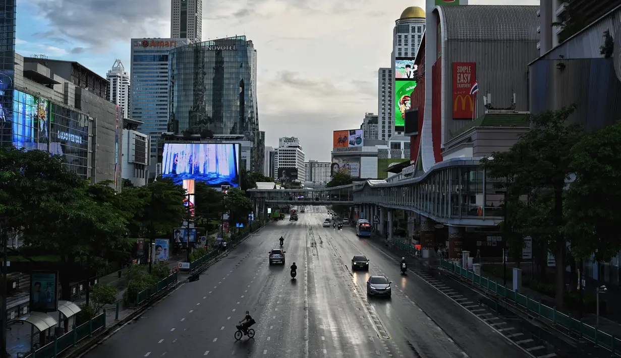 Kendaraan berjalan di persimpangan Ratchaprasong pada hari pertama penguncian COVID-19 yang lebih ketat di Bangkok, Senin (12/7/2021).  Thailand menerapkan lockdown untuk menekan laju penyebaran virus corona pada Senin, 12 Juli 2021 di Bangkok dan provinsi sekitarnya. (Lillian SUWANRUMPHA/AFP)