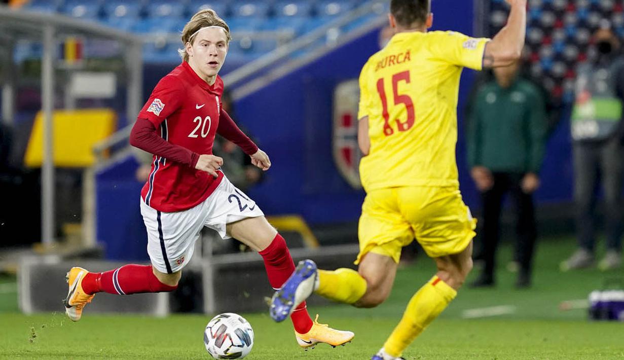 Pemain Norwegia, Jens Petter Hauge, berusaha melewati pemain Rumania, Andrei Burca, pada laga UEFA Nations League di Stadion Ullevaal, Minggu (11/10/2020). Norwegia menang dengan skor 4-0. (Vidar Ruud /NTB scanpix via AP)