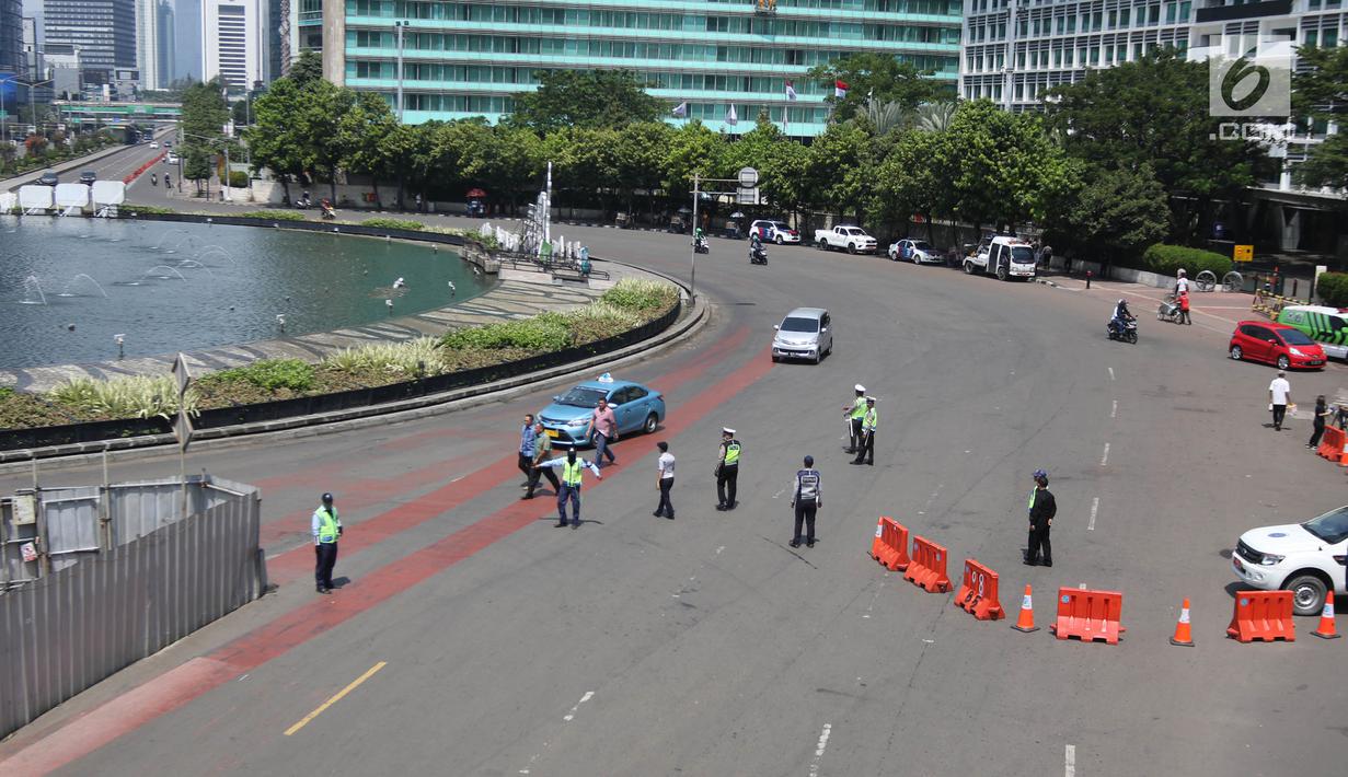 Petugas melakukan rekayasa lalu lintas imbas dari kegiatan May Day 2018 di kawasan Harmoni, Jakarta Pusat, Selasa (1/5). Berdasarkan data kepolisian, ada sekitar 30 ribu buruh akan ke Jakarta. (Liputan6.com/Arya Manggala)
