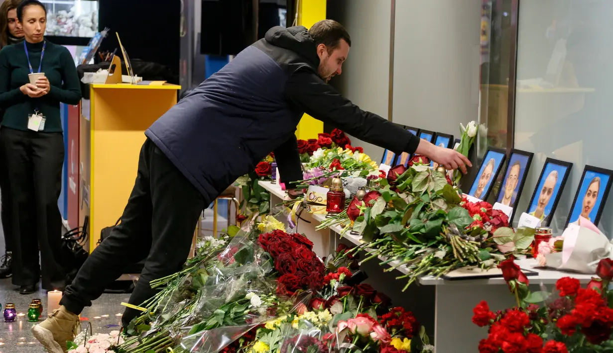 Kerabat salah satu kru pesawat 737-800 Ukraina yang jatuh di Iran, meletakkan bunga pada peringatan di bandara internasional Borispil, Kiev, Rabu (8/1/2020). Pesawat yang membawa 176 orang itu jatuh setelah lepas landas dari bandara utama Teheran dan menewaskan semua penumpang. (AP/Efrem Lukatsky)
