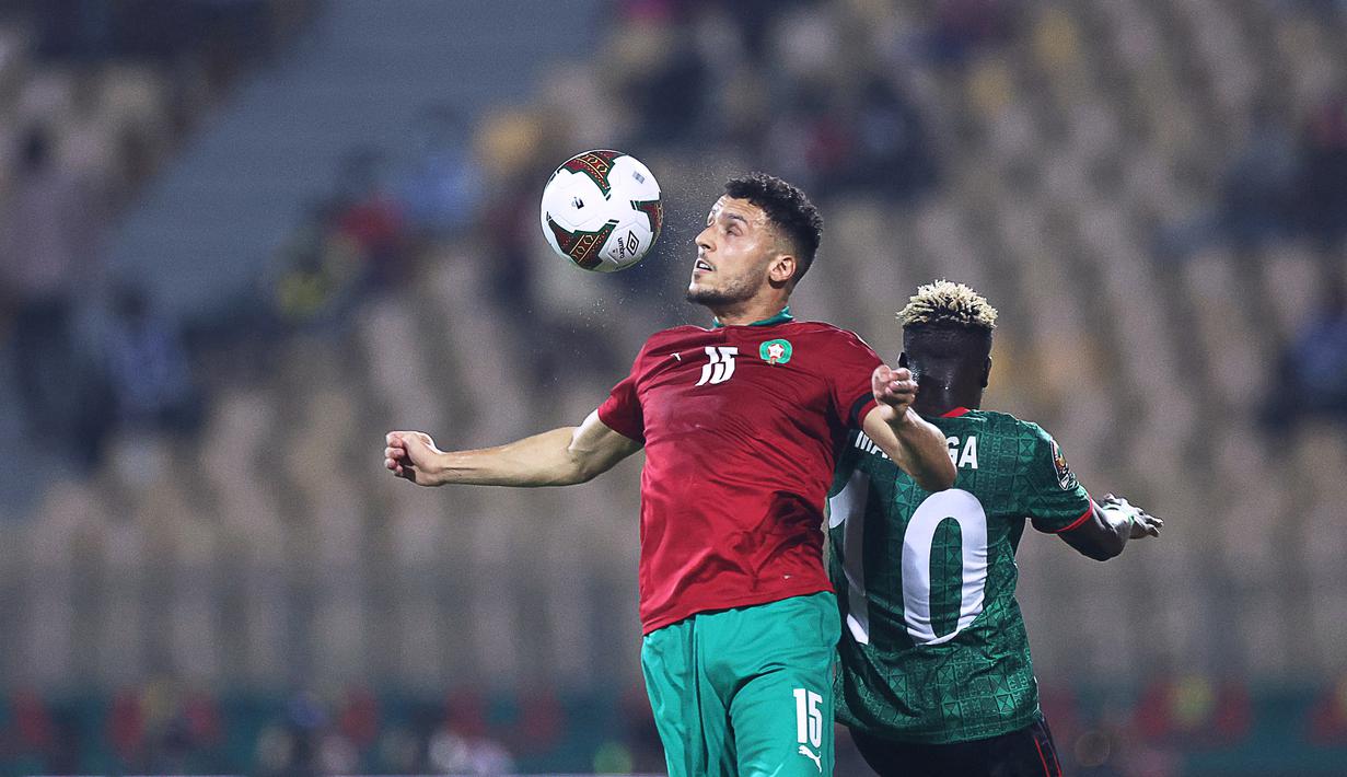 Gelandang Maroko Selim Amallah (kiri) berbeut bola dengan gelandang Malawi Francisco Madinga pada babak 16 besar Piala Afrika 2021 di Ahmadou Ahidjo Stadium, Yaounde, Rabu (26/1/2022) dini hari WIB. Achraf Hakimi menjadi penentu kemenangan Maroko atas Malawi, 2-1. (Kenzo Tribouillard/AFP)