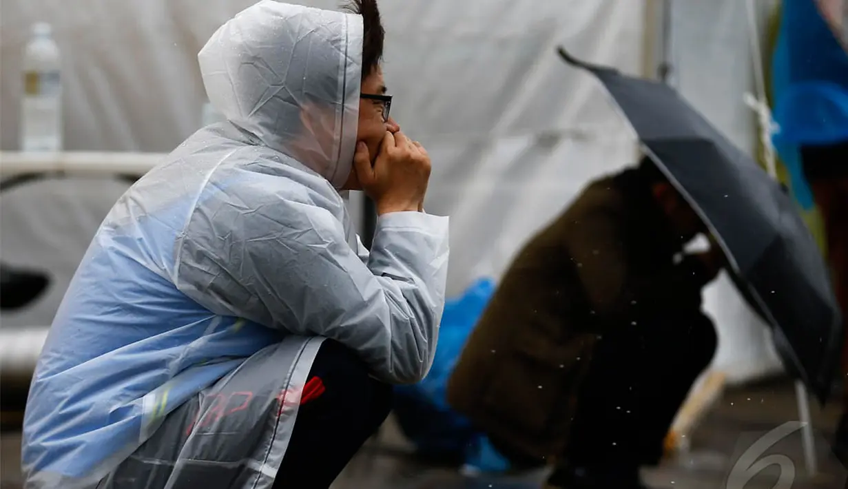 Kerabat dari seorang penumpang yang hilang dari Feri Sewol melihat ke laut menunggu kabar dari Tim SAR, Minggu (27/04/2014) (Reuters/ Kim Kyung-Hoon).