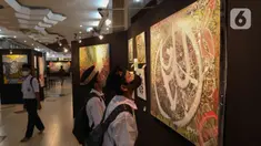 Pengunjung melihat karya pada Pameran Kaligrafi Kontemporer Internasional di Masjid Raya Jakarta Islamic Center, Jakarta, Senin (18/4/2022). Pameran digelar dalam rangkaian peringatan Nuzulul Quran itu menghadirkan lebih dari 100 karya seniman kaligrafi dari 26 negara. (Liputan6.com/Herman Zakharia)