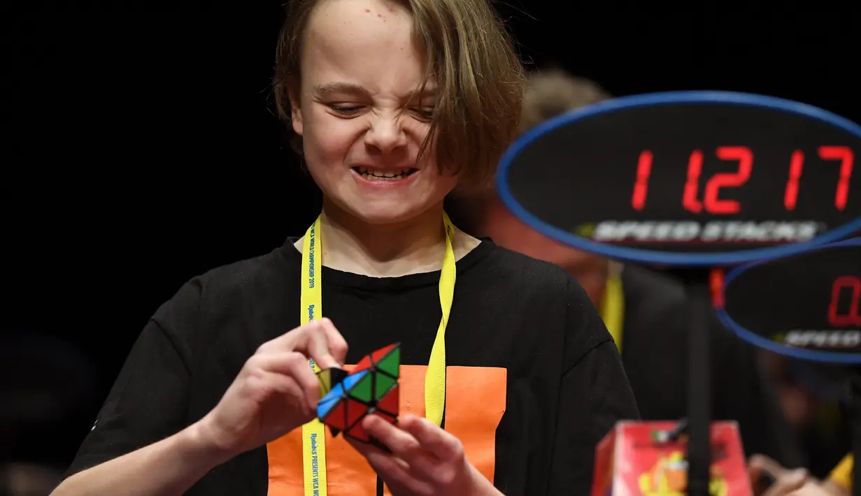 Seorang anak semangat memecahkan permainan rubik pada kejuaraan kubus Rubik Dunia di Melbourne, Australia (12/7/2019). Kejuaraan Dunia diadakan setiap dua tahun dan telah menarik 905 pesaing dari seluruh dunia yang bersaing dalam 18 acara yang berbeda. (AFP Photo/William West)