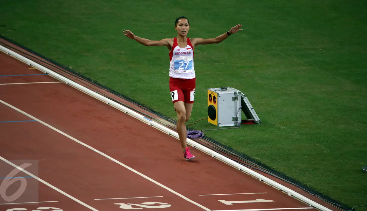 Atlet Indonesia, Rini Budiarti mengangkat tangan jelang finis lari halang rintang 3.000 meter SEA Games ke-28 di National Stadium, Singapura, (12/6/2015). Rini finish pertama dengan catatan waktu 10 menit 20,40 detik. (Liputan6.com/Helmi Fithriansyah)