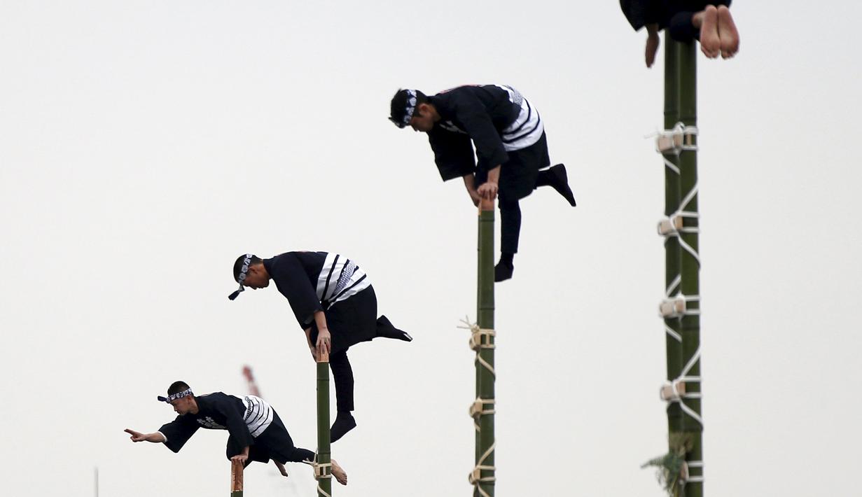 Anggota perkumpulan Edo saat menampilkan atraksi diatas ujung bambu di Tokyo, Jepang, (6/1). Pertunjukan ini sebagai perayaan tahun baru 2016 oleh para petugas pemadam kebakaran Tokyo.( REUTERS / Yuya Shino)
