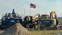 Bendera Amerika Serikat berkibar di atas sebuah alat berat di lokasi pabrik kendaraan listrik Hyundai Motor Group di Ellabell, Georgia, Jumat (5/9/2025). (Dok. AP/Russ Bynum)&nbsp;&nbsp;&nbsp;
