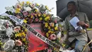 Sebuah karangan bunga bergambar Jopi dibawa saat aksi kamisan di depan Istana Negara, Jakarta, Kamis (2/7/15). Dalam aksinya mereka meminta kepada Jokowi untuk menuntaskan kasus pembunuhan Jopi. (Liputan6.com/Herman Zakharia)