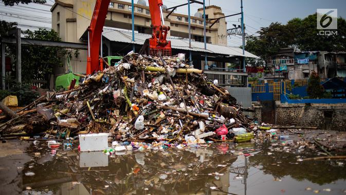 Alat berat mengangkut sampah yang menumpuk di Pintu Air Manggarai, Jakarta, Selasa (4/12). Pembersihan dilakukan untuk melancarkan aliran sungai dan mencegah datangnya banjir saat memasuki musim hujan di wilayah tersebut. (Liputan6.com/Faizal Fanani)