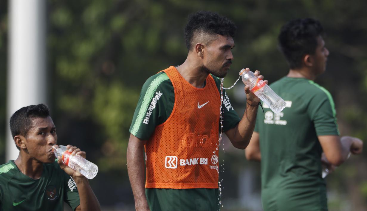 Pemain Timnas Indonesia U-22, Rifal Lastori, melepas dahaga saat latihan di Lapangan ABC Senayan, Jakarta, Senin (7/1). Latihan ini merupakan persiapan jelang Piala AFF U-22. (Bola.com/Vitalis Yogi Trisna)