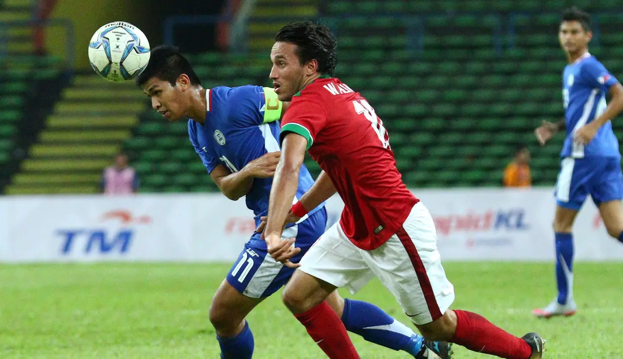 Pemain Filipina Julian Mariano Clarino berebut bola dengan pemain Timnas Indonesia U-22, Ezra Harm Ruud Walian pada babak penyisihan grup B SEA Games di Stadion Shah Alam, Selangor, (17/8). Indonesia menang 3-0 atas Filipina. (AP Photo / Vincent Phoon)