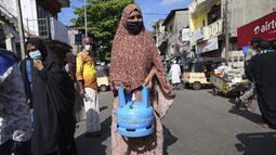 Seorang wanita Sri Lanka menunggu antrean isi ulang tabung gas memasaknya saat kekurangan pasokan di KolomboSelasa (4/1/2022). Antrean panjang selama berjam-jam telah menjadi pemandangan biasa dalam beberapa hari terakhir dalam upaya untuk membeli tabung gas domestik. (AP Photo/Eranga Jayawardena).