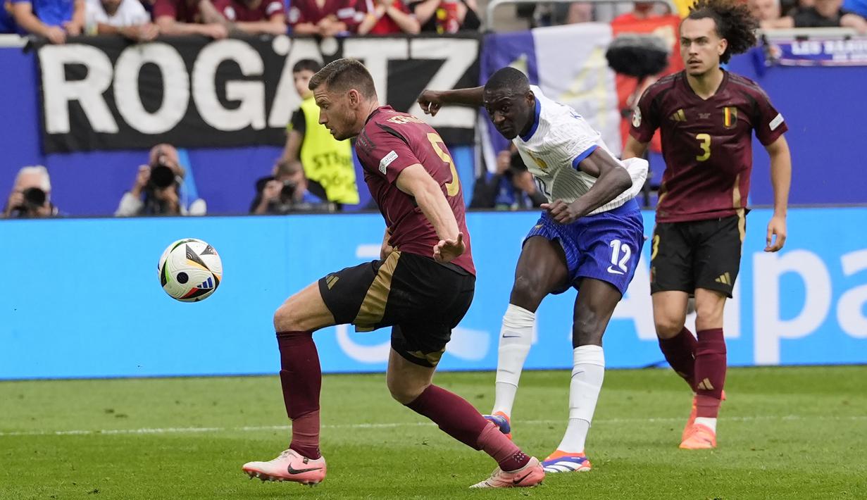 Striker Timnas Prancis, Randal Kolo Muani (tengah) melepaskan tendangan yang berusaha diblok bek Timnas Belgia, Jan Vertonghen pada laga babak 16 besar Euro 2024 di Merkur Spiel-Arena, Dusseldorf, Jerman, Senin (1/7/2024). (AP Photo/Martin Meissner)