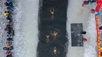 Foto udara pada 25 Januari 2022 menunjukkan penggemar renang musim dingin berenang di danau yang sebagian beku di Shenyang, di provinsi Liaoning, China. Penduduk lokal banyak menggemari kebiasaan berenang di musim dingin di mana banyak sungai dan danau-danau mulai membeku. (STR/AFP)